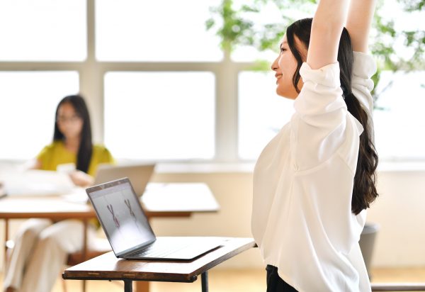 会社で伸びをする女性